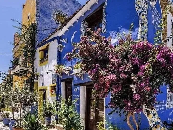 Facciata blu con maioliche e fiori a Borgo Parrini