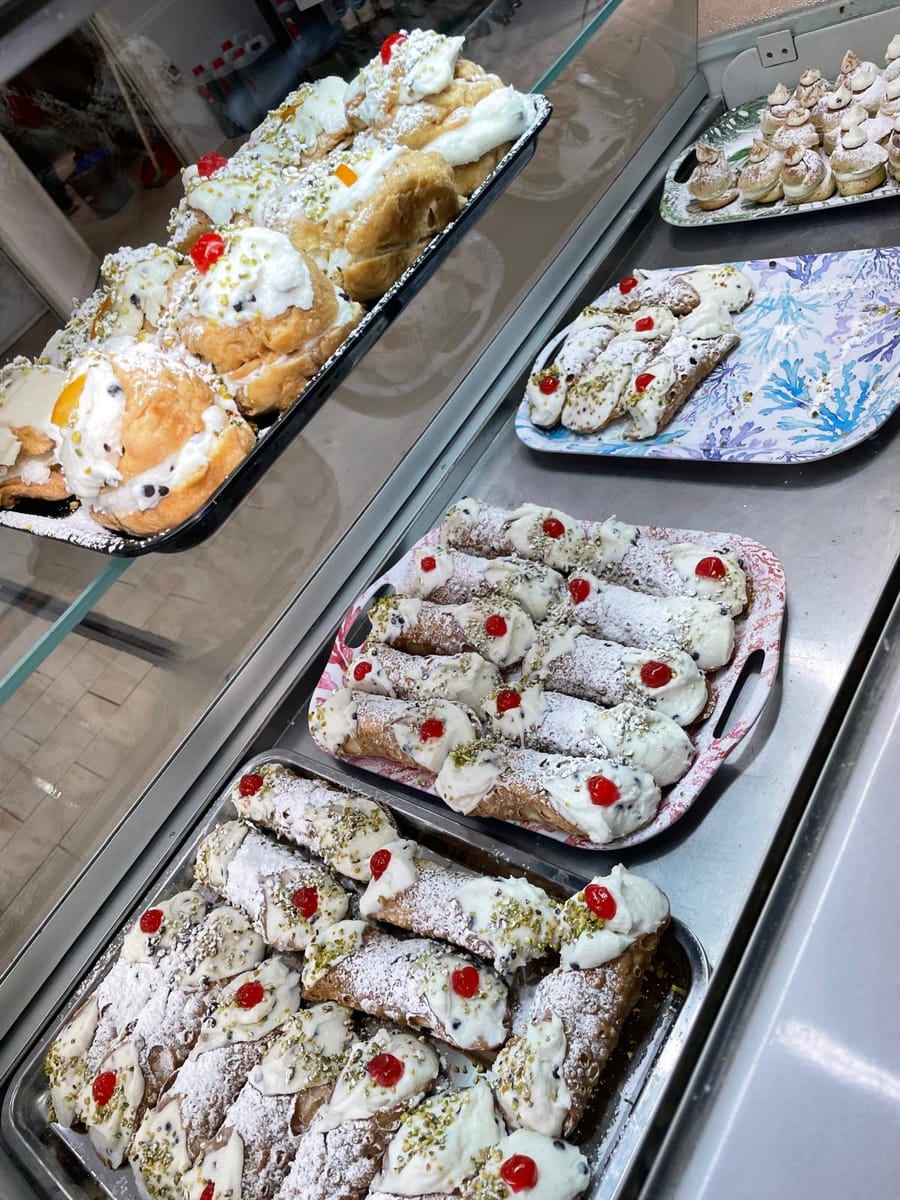 Vassoi di cannoli siciliani alla ricotta con ciliegine candite e granella di pistacchio