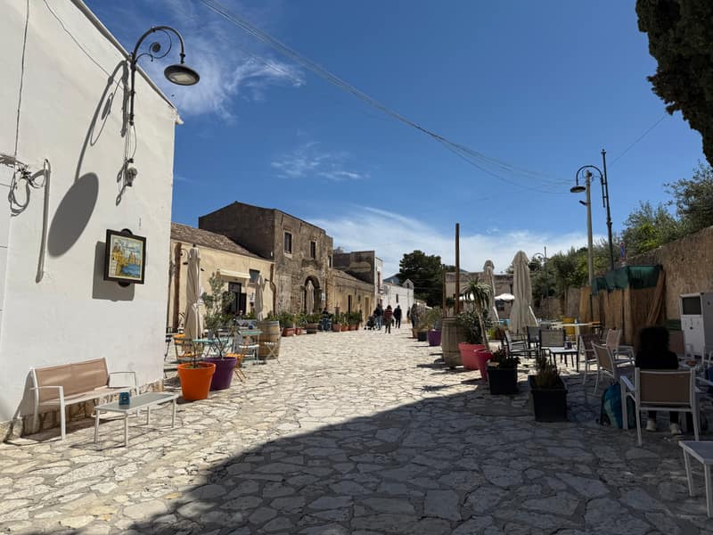 La via principale del borgo di Scopello con l’antico baglio sullo sfondo